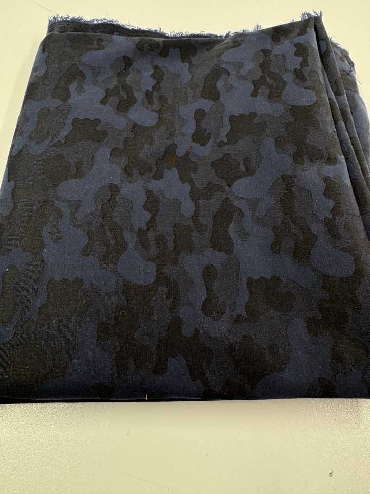 The REMNANT - Cotton Sateen- 200cm from Super Cheap Fabrics is a dark blue fabric with a black camouflage pattern, measuring 115cm wide by 200cm long, shown folded on a light surface.