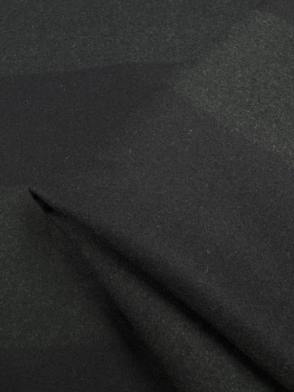 Close-up of Super Cheap Fabrics' Virgin Wool in a two-tone black khaki pattern. The soft, heavy weight wool displays a subtle plaid design, with gentle folds emphasizing its texture and weave. Width: 150cm.