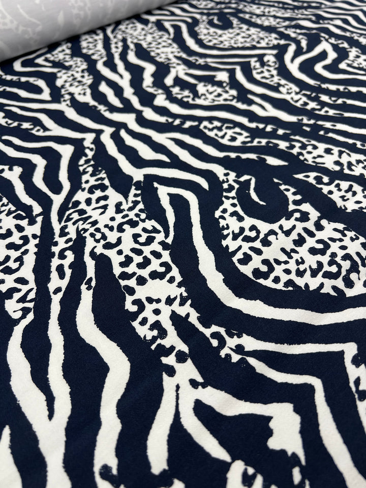 Close-up of Super Cheap Fabrics' Printed Bengaline - Navy Fusion (150cm), a medium-weight fabric with bold, abstract animal print and subtle two-way stretch for comfort.