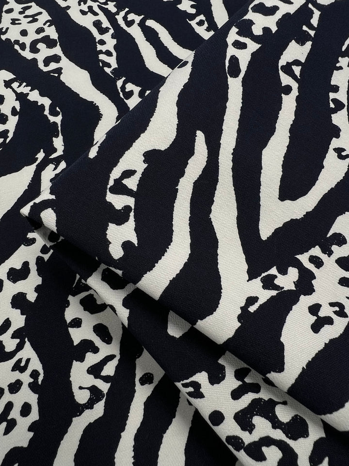 Printed Bengaline - Navy Fusion by Super Cheap Fabrics, 150cm wide, features medium-weight fabric with bold navy animal print and two-way stretch woven texture, showcased closely to highlight its striking design.