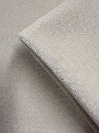 A close-up of two pieces of Super Cheap Fabrics' Oxford Velvet - Warm Snow (144cm), light beige with a suede-like, soft, and subtly textured surface, layered together.