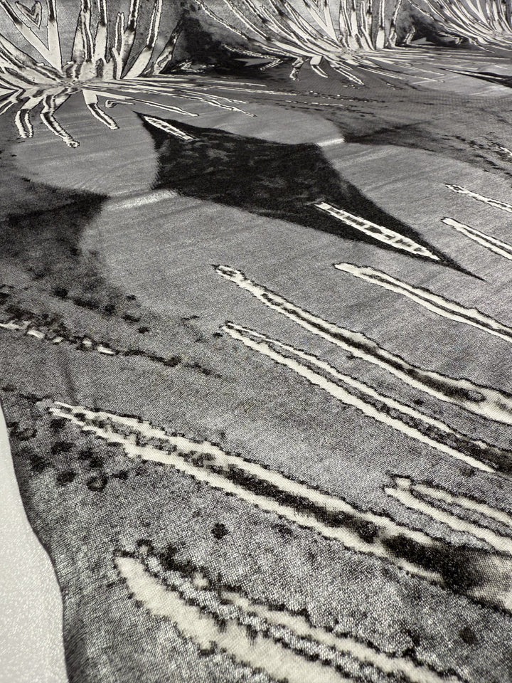 Close-up of Super Cheap Fabrics' Viscose Knit - Cosmic Burst (145cm), showcasing dynamic black-and-white abstract, leaf-like patterns on breathable, textured fabric—ideal for comfortable summer wear.