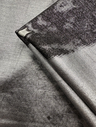 Close-up of Super Cheap Fabrics' Viscose Knit - Cosmic Burst (145cm), a silver and black stretch viscose with a subtle abstract pattern, shiny metallic look, smooth finish, and breathable—perfect for summer projects.