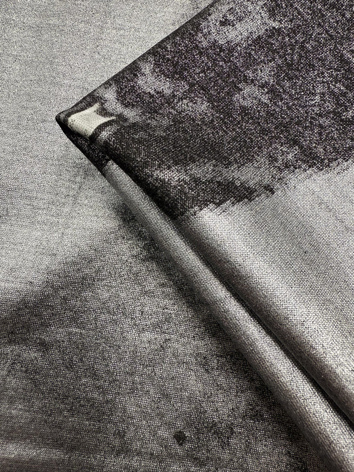 Close-up of Super Cheap Fabrics' Viscose Knit - Cosmic Burst (145cm), a silver and black stretch viscose with a subtle abstract pattern, shiny metallic look, smooth finish, and breathable—perfect for summer projects.