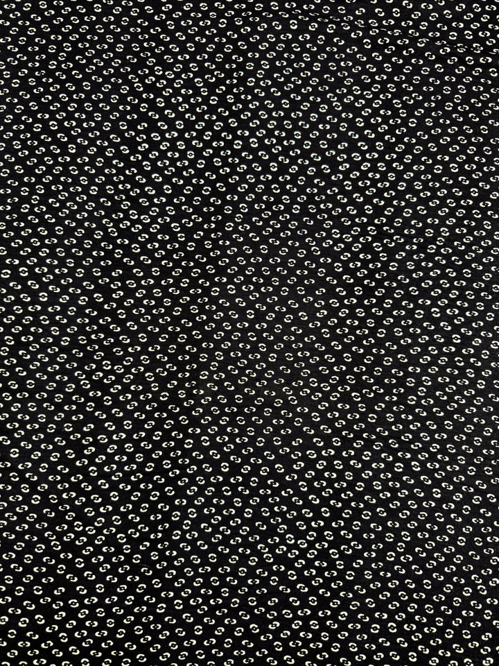 Super Cheap Fabrics’ Viscose Knit - Micro Dot (145cm) is a black fabric with small white diagonal dots, offering breathable comfort and stylish polka-dot texture—perfect for summer wear.