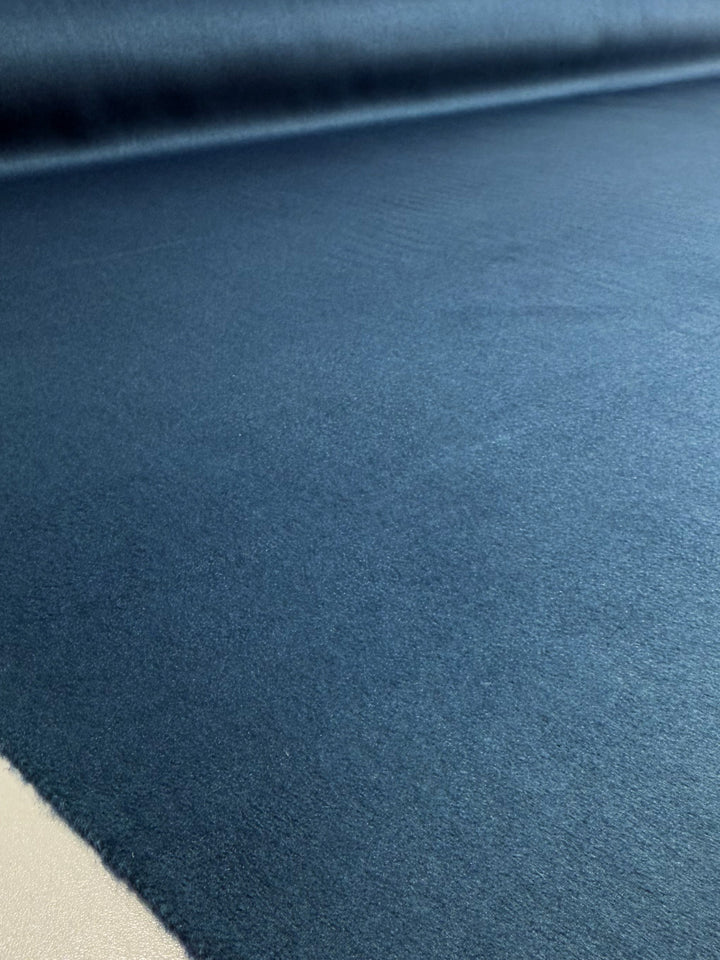 A close-up view of Super Cheap Fabrics’ Wool Cashmere - Blue Steel (150cm) shows the smooth, dark blue luxury fabric laid flat with a light-colored edge visible in the bottom left corner.