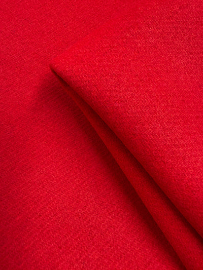 Close-up of Super Cheap Fabrics' Wool Cashmere in Cherry Red (150cm), an extra heavy weight fabric with a slightly textured surface, folded to highlight its soft, luxurious layers.