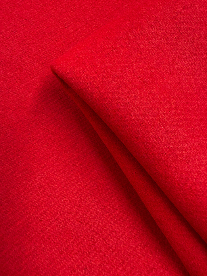 Close-up of Super Cheap Fabrics' Wool Cashmere in Cherry Red (150cm), an extra heavy weight fabric with a slightly textured surface, folded to highlight its soft, luxurious layers.