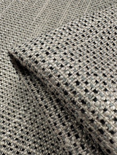 The Upholstery Logan - Rhino from Super Cheap Fabrics, sized at 145cm, showcases a heavy-weight, detailed woven texture in grey and black with a small check pattern. Ideal for adding textured accents.