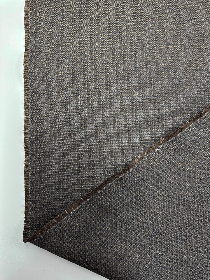 Close-up of Basket Weave Upholstery - Tuco 035 by Super Cheap Fabrics, featuring two dark gray heavy weight pieces with a coarse woven pattern and rough texture. The top piece is diagonally placed over the other on a light surface, showing frayed edges where the high durability fabric is cut.
