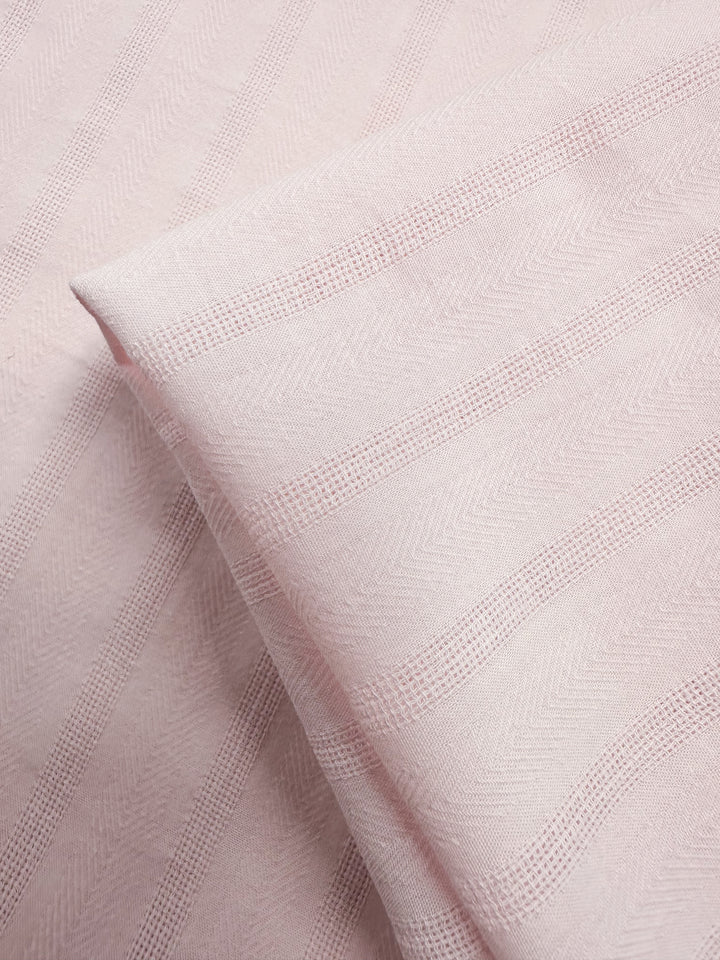 Close-up of Super Cheap Fabrics’ Textured Cotton - Silver Pink - 143cm, featuring subtle striped patterns with a mix of smooth and raised lines for an elegant look.