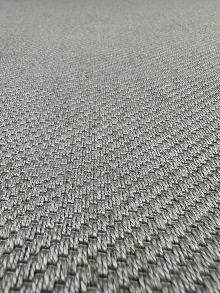 Close-up of Super Cheap Fabrics' Twill Upholstery - Rex 370 - 150cm, highlighting the gray woven surface and detailed interlaced fiber pattern. Low-angle shot emphasizes the depth and texture of this durable upholstery fabric.