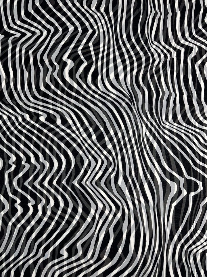 The Printed Chiffon - Zebraic (150cm) by Super Cheap Fabrics showcases a black and white abstract pattern with wavy, distorted lines, creating a dynamic, hypnotic effect ideal for high fashion designs on lightweight polyester fabric.