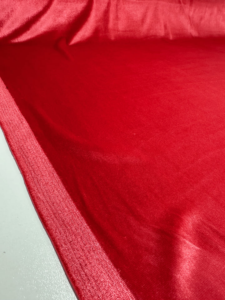 A close-up shows the vibrant Rose of Sharon Stretch Velour from Super Cheap Fabrics. Measuring 170cm, it displays a smooth texture and slight sheen with edges visible on the left side.