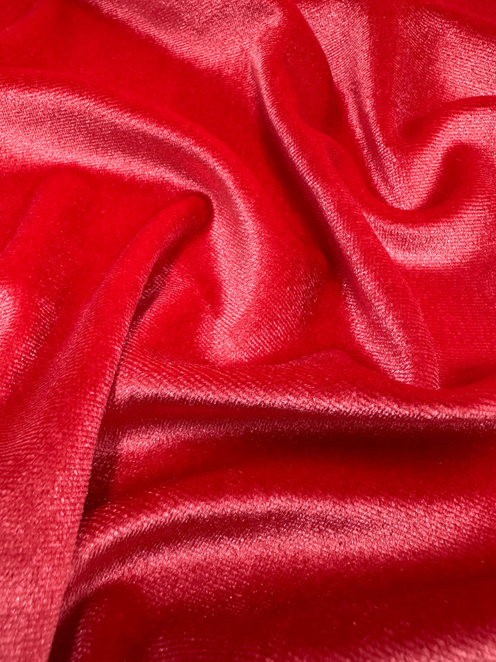 A close-up of Super Cheap Fabrics' Stretch Velour in Rose of Sharon, 170cm, showcases its plush and luxurious texture. The velvet fabric exhibits gentle folds and a soft sheen, elegantly reflecting light akin to rich velour.