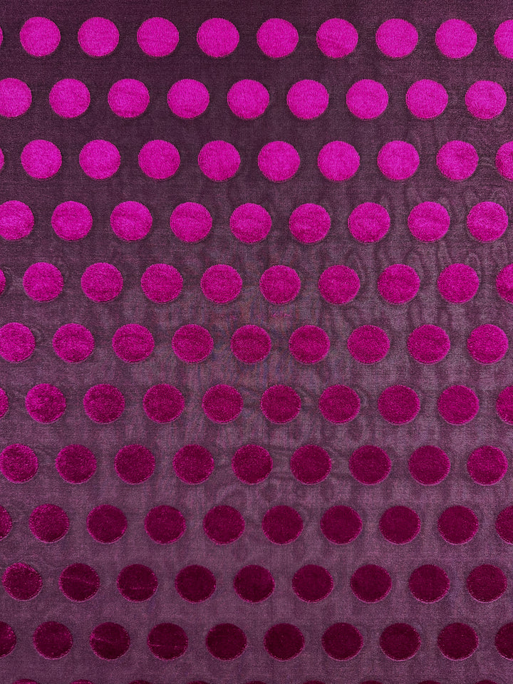 Super Cheap Fabrics presents Burnout Velvet - Festival Fuchsia, a luxurious fabric with shiny magenta dots on deep purple, forming a mesmerizing pattern. Ideal for elegant evening gowns, it measures 155cm wide.