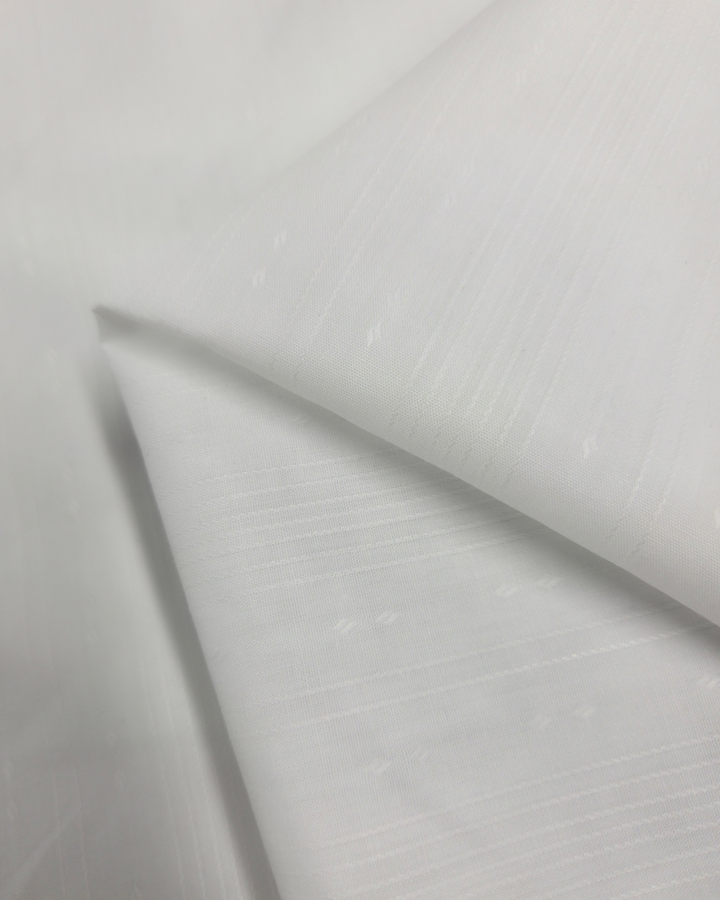 The Poplin - Tex White fabric by Super Cheap Fabrics is a lightweight, folded poly/cotton material featuring a subtle diagonal stripe pattern. Its smooth texture makes it ideal for childrenswear. Width: 147cm.
