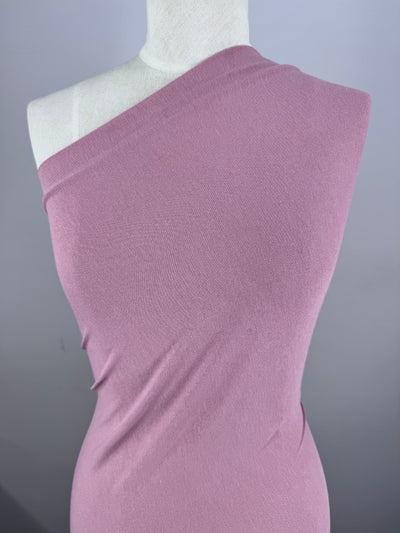 A mannequin displays a light pink, one-shoulder bodycon dress tailored from Super Cheap Fabrics' Cotton Lycra in Fox Glove (155cm), set against a plain gray backdrop.
